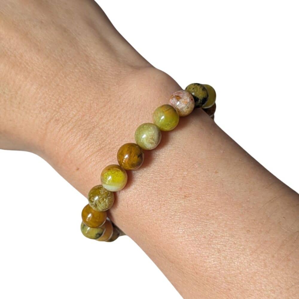 Bracelet en opale verte 8 mm porté au poignet, un bijou élégant en pierre naturelle pour retrouver l'harmonie, l'optimisme et l'équilibre émotionnel.