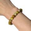Bracelet en opale verte 8 mm porté au poignet, un bijou élégant en pierre naturelle pour retrouver l'harmonie, l'optimisme et l'équilibre émotionnel.