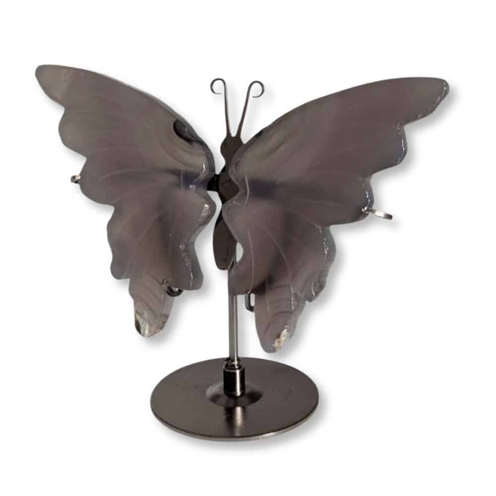 Vue de trois quarts du papillon en agate grise et de ses ailes sculptées